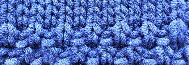 旗帜与明亮的蓝色针织织物与简单和花式图案。爱好工艺背景，拷贝空间图片下载