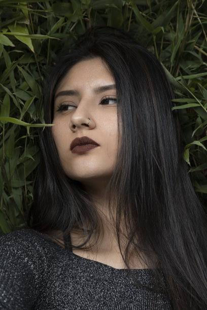 一张年轻女子的脸上画着妆，留着直发，背景是几片植物、画室和大自然图片下载