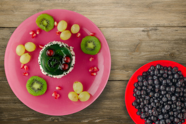 蛋糕和水果的甜点葡萄，猕猴桃，石榴的一个木制图片下载