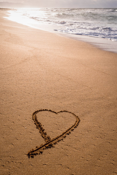 心的形状写在沙子上，用波浪冲刷着图片下载