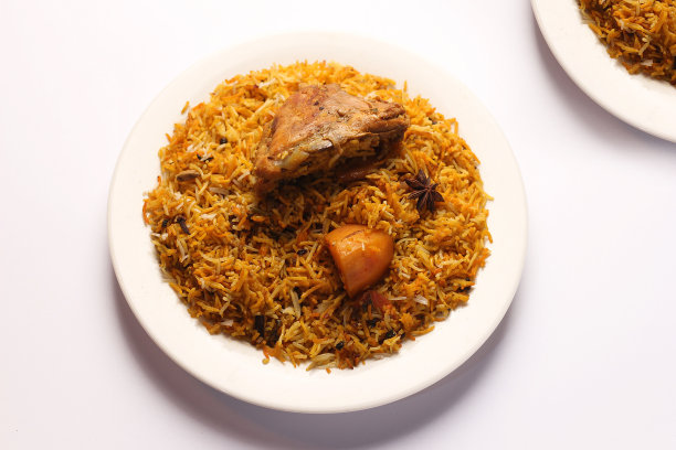 美味的香辣鸡饭放在白色的盘子里，配上白色的背景，印度或巴基斯坦食物。图片下载