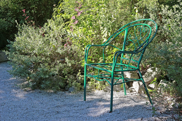 绿色的花园椅子在人行道的一边图片下载