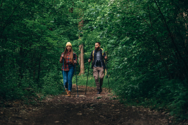 两个徒步旅行者在背着背包的情况下使用登山杖图片下载