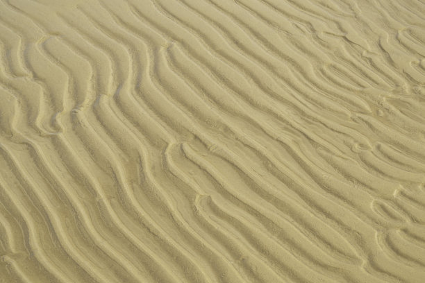 海岸上的沙子纹理。波浪沙背景特写。图片下载