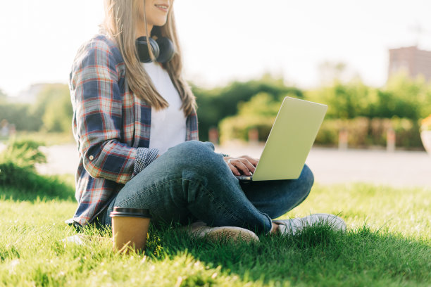 坐在草地上用笔记本电脑的女人图片下载
