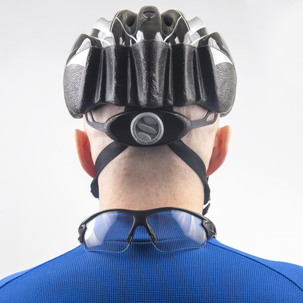 男性骑自行车在一个自行车头盔从后面在一个光的背景图片下载