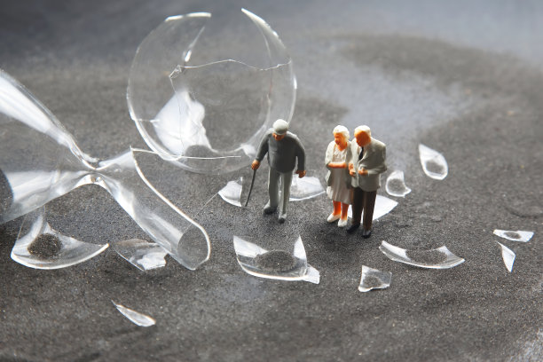 微型的人。老人走在破碎的沙漏附近。损失生命的时间。希望危机和老年问题图片下载