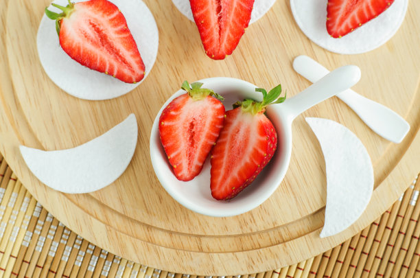 装有新鲜草莓的小碗，可以用来准备自制面膜。天然美容及水疗配方。俯视图，复制空间。图片下载