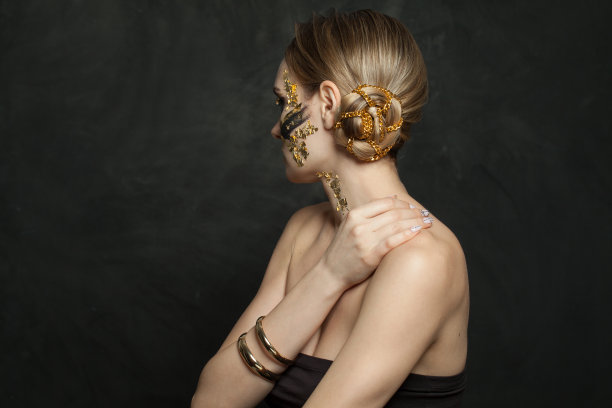 美丽的女人与时尚的发型，金色的链子在黑色的背景图片下载