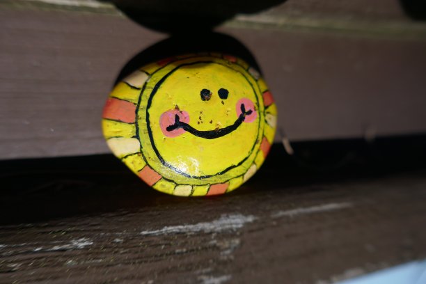 鼓励可爱微笑的黄色太阳画在善良的岩石上图片下载