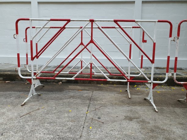 交通障碍漆成红色和白色。设置障碍物象征禁止汽车通行。还有停在隔离区的其他车辆。图片下载