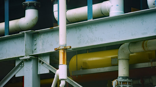 梁、梁和管的建筑照片，背景中有其他部件，涂漆的管螺栓和螺母紧固件图片下载