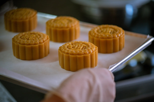 在烘烤前的烤盘上，女人们正在制作自制月饼糕点的面团图片下载