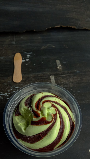 这张照片是一张牛油果味冰淇淋放在一个黑色背景的杯子里的照片图片下载