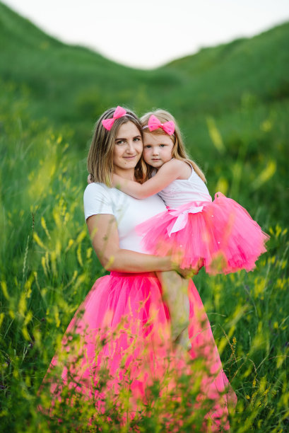 年轻的母亲拥抱着女儿。全家去公园度假。描绘妈妈和孩子在一起的自然。妈妈带着一个小女孩在户外散步。快乐的母亲节。家人看。关闭了。图片下载