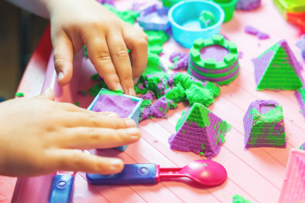 孩子的手在玩五彩缤纷的运动沙图片下载