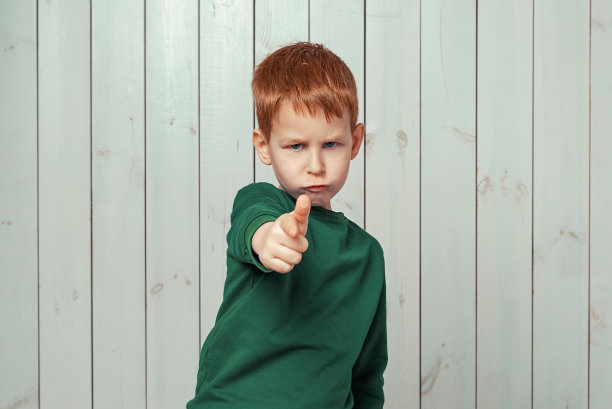 7-9岁的姜小男孩指着镜头，认真地看了看图片下载