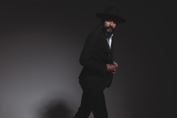 年轻的商人安排着他的燕尾服，摆着姿势图片下载