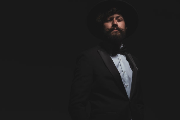 帅气的商人在他的酷酷的礼服摆出傲慢的姿势图片下载