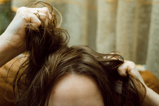 混乱,头发的问题。手里拿着乱发的女人。图片下载