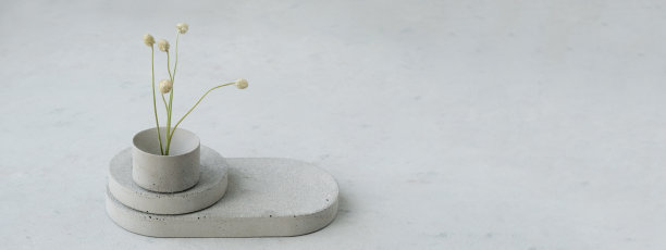 横幅。基座或产品展示混凝土平台，在绿色背景上点缀着干燥的极简主义花朵和自然树叶。本空间图片下载