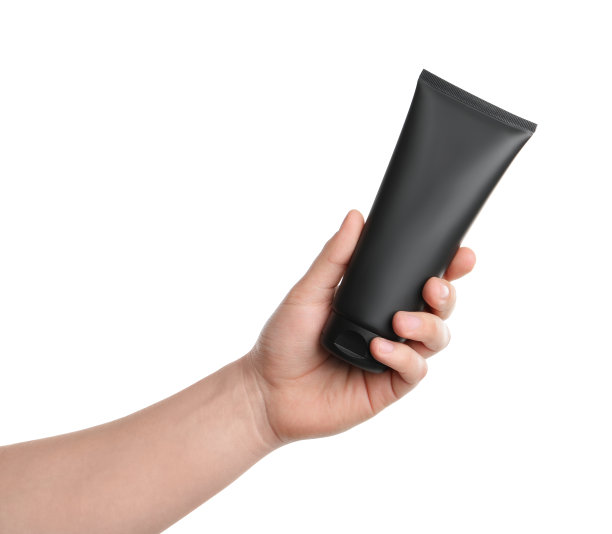 男人拿着一管面霜孤立在白色，特写。模型设计图片下载