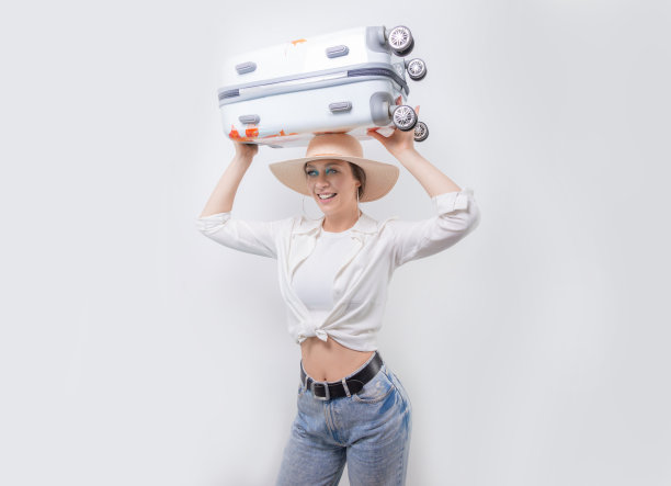 头顶着手提箱的漂亮女孩，旅游概念图片下载