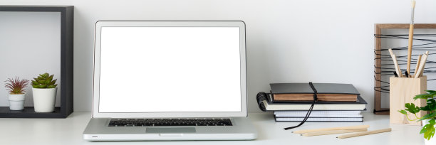 家庭办公室。靠白墙的桌子上放着一台打开的笔记本电脑。模型。副本的空间。图片下载