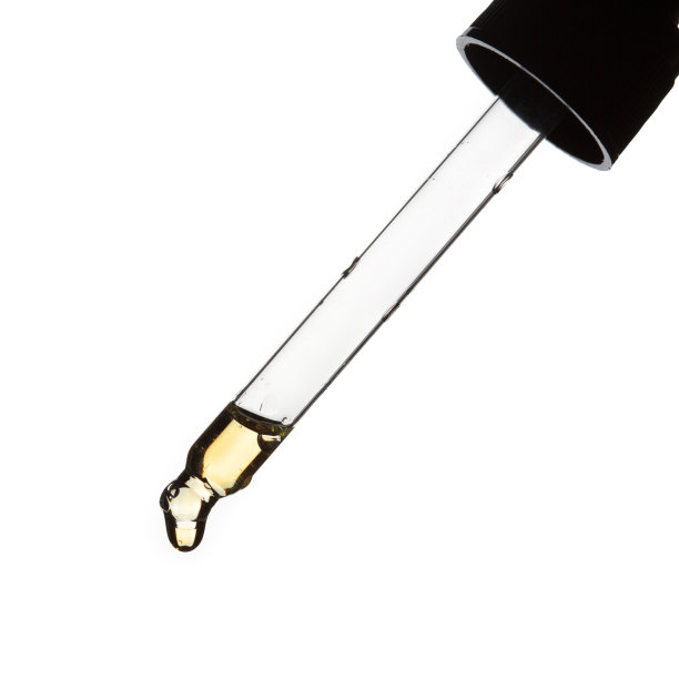 一滴精油滴从移液管特写在白色背景图片下载