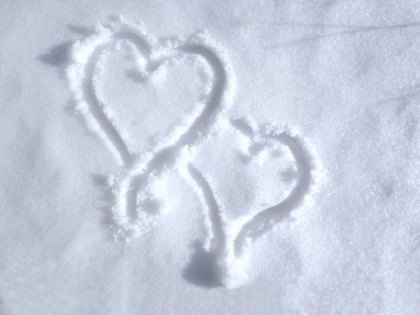 画在新鲜的白雪表面，代表两颗心在一起。优雅的绘画象征爱的情人节在纹理的表面图片下载