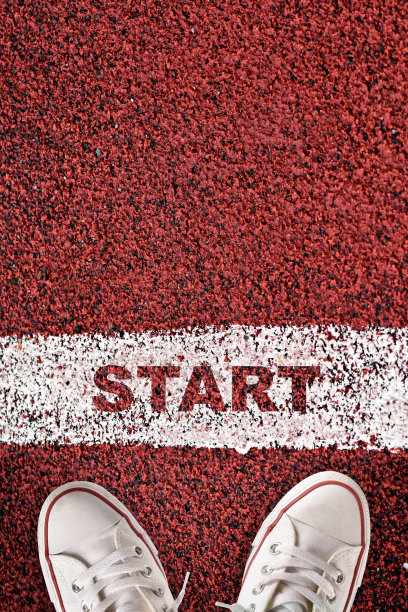 起跑线和红色运动轨道上的白色球鞋的顶部视图的开始字图片下载