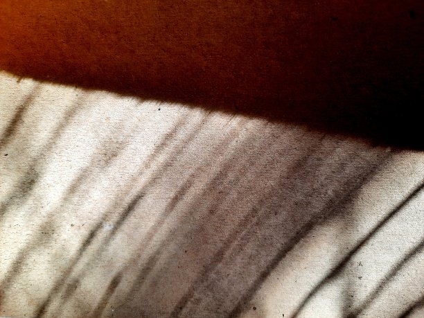 早晨的阳光阴影在纸板背景上图片下载