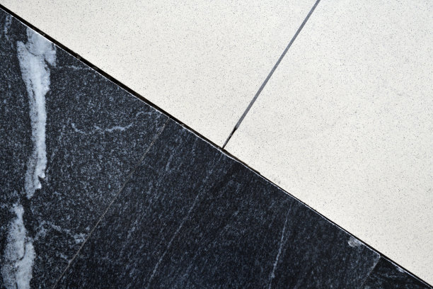 明暗瓷砖的接缝。一个黑色和白色瓷砖表面接缝的特写。图片下载