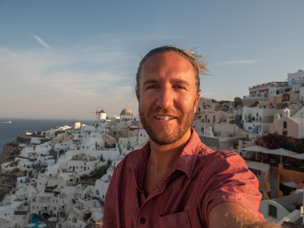 日落时分，男游客在圣托里尼岛自拍图片下载
