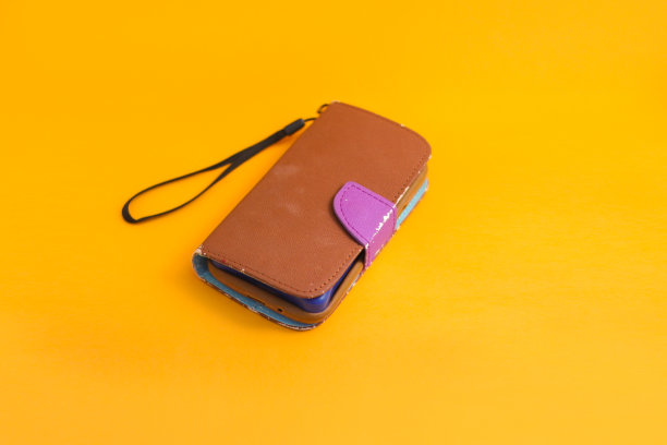 旧的使用棕色手机壳孤立在橙色背景图片下载