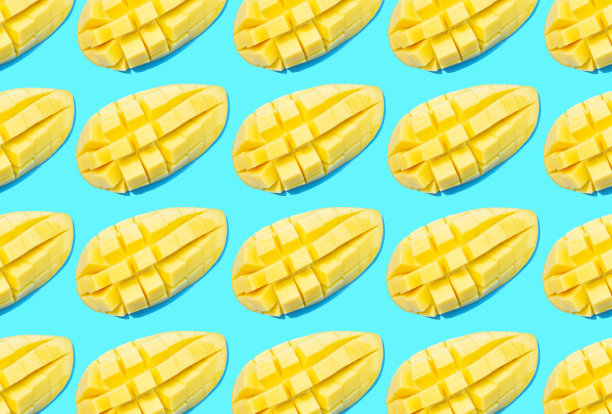 切割的黄色芒果在蓝色背景上的图案，俯视图。图片下载