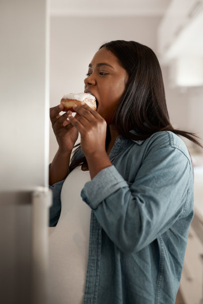 一张孕妇在家吃甜甜圈的照片图片下载