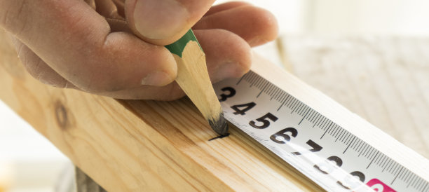 木匠用红铅笔做木制部分的标记。图片下载