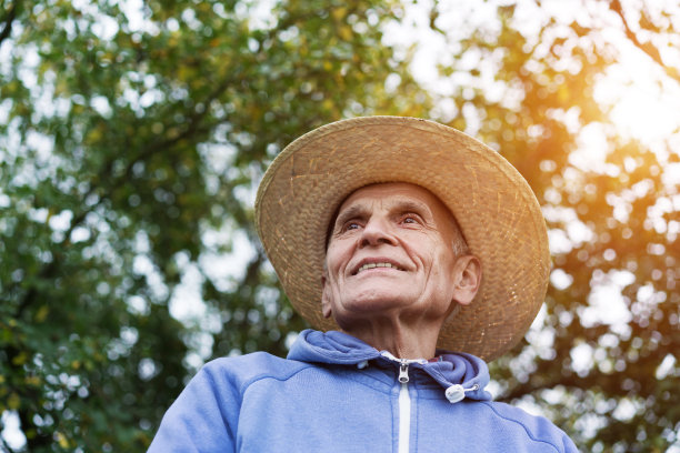 户外肖像的老农民与皱纹的脸和草帽。图片下载