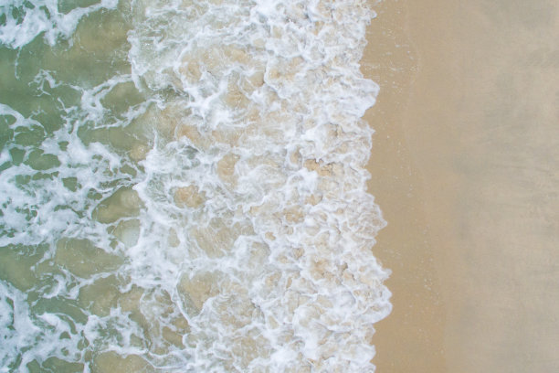 柔软的蓝色海浪在沙滩上。图片下载