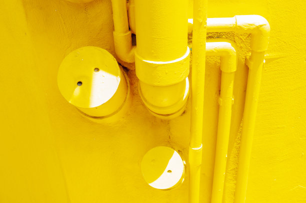 管道在黄色单色墙上图片下载