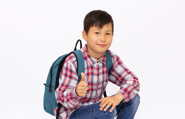 英俊的年轻亚洲男孩与背包微笑在白色的背景图片下载