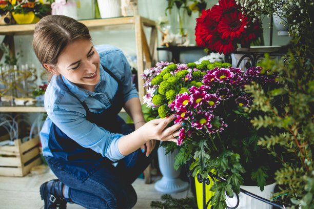 在城市街道花店或花店工作的年轻成年妇女。图片下载