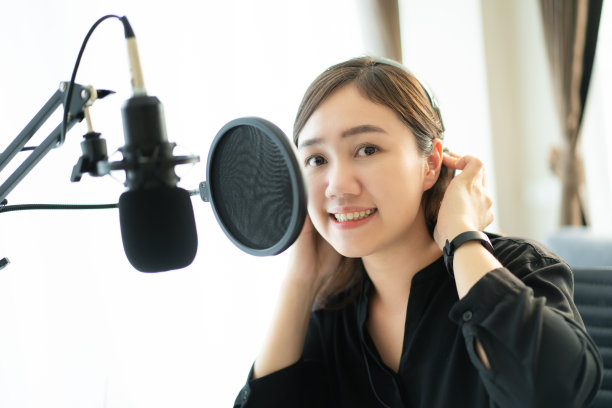一个亚洲年轻女子在网上播客站做播客。图片下载