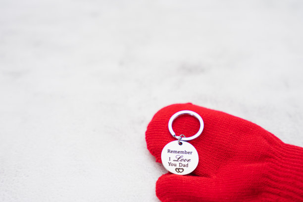 以石头为背景，代表父亲节里孩子拿着爱的钥匙链送给父亲的礼物场景图片下载