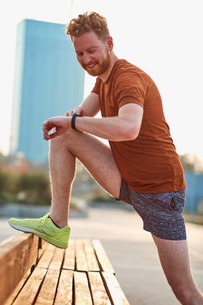 在公园长椅上伸懒腰的运动员。图片下载