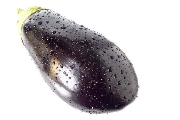 白色背景上滴着水的茄子。图片下载