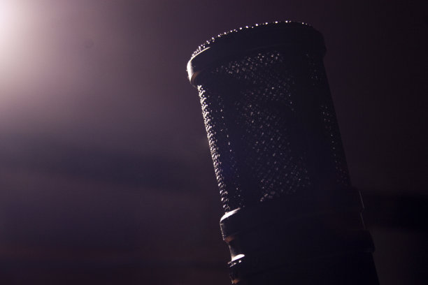 麦克风。录音室里的麦克风。音乐studio.Podcasts.Music调优。麦克风孤立。一个戏剧性的镜头，麦克风在黑暗中与光线来自背景图片下载