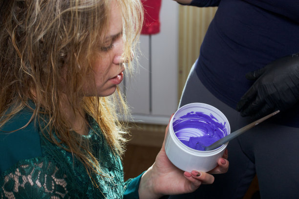 理发师在起作用。染发。使用染发剂。这个女孩手里拿着一罐颜料。图片下载