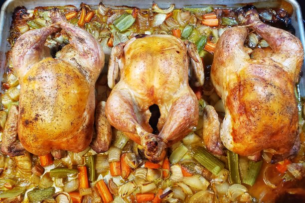 刚从烤箱里出来的平底锅上放着三只整熟的鸡图片下载